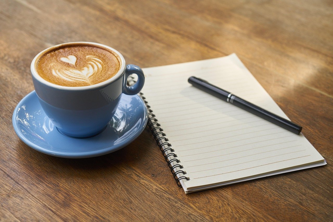 Beslutninger i parforholdet: Når dere trenger ulik betenkningstid Åpen notatbok med penn og en blå kaffekopp på et trebord